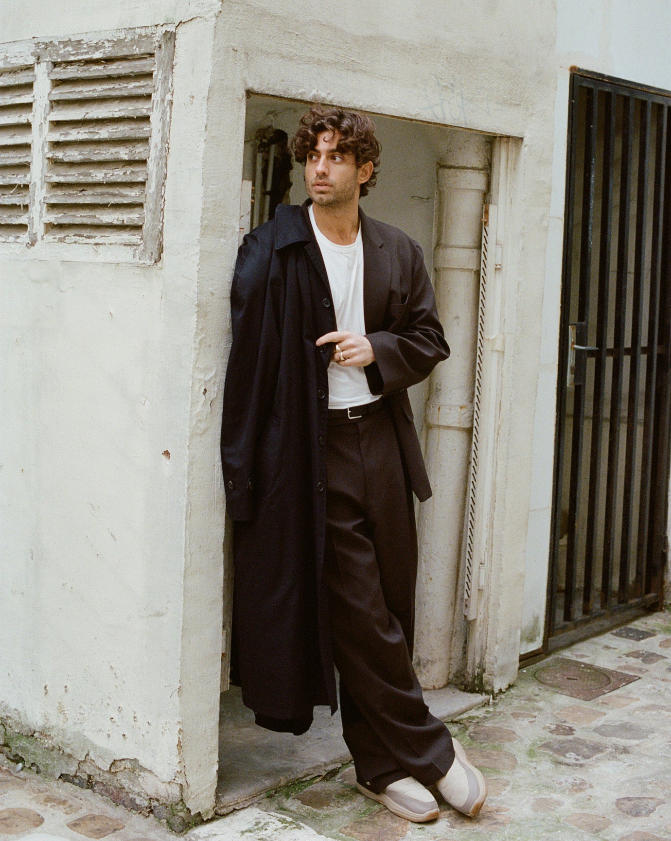 A male model posing in the street wearing the Frankie Shop Beo suit in dark espresso. 