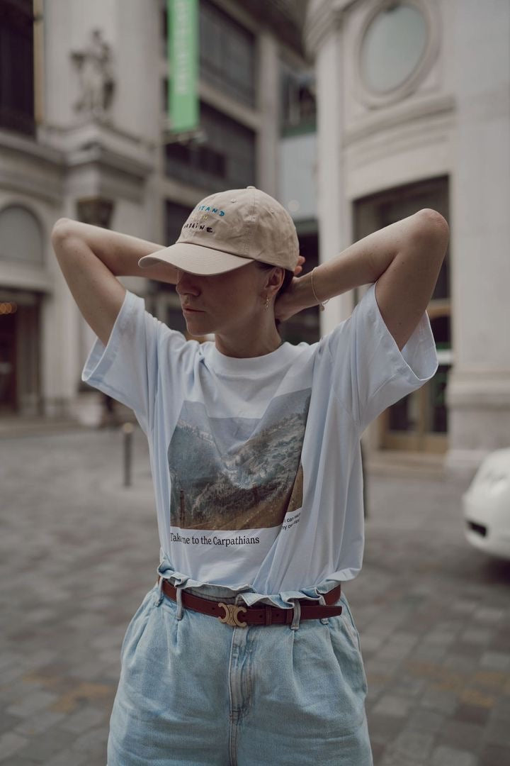 Woman photographed wearing "I stand with Ukraine" cap.