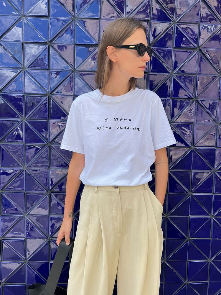 Woman photographed wearing "I stand with Ukraine" T-shirt.