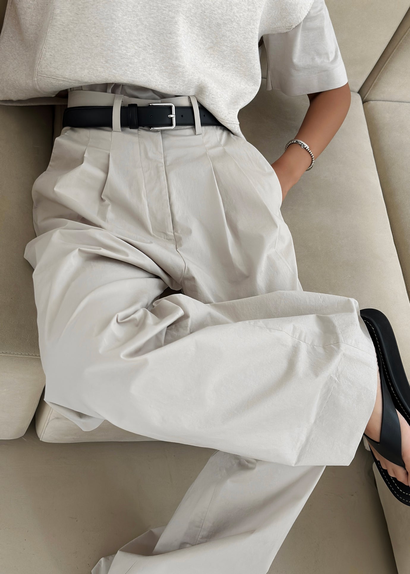 A close up image of a model wearing The Frankie Shop Jayden wide pants in taupe. 