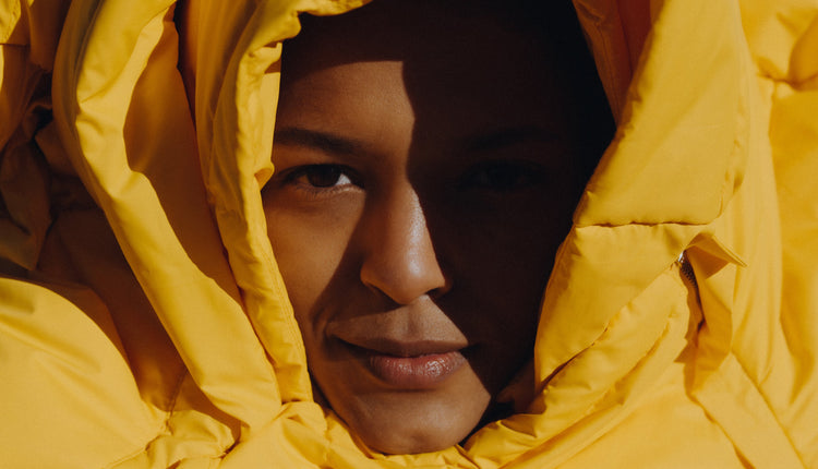 Close up of model wearing the Val puffer jacket in yellow. Photographed by Charlotte Lapalus