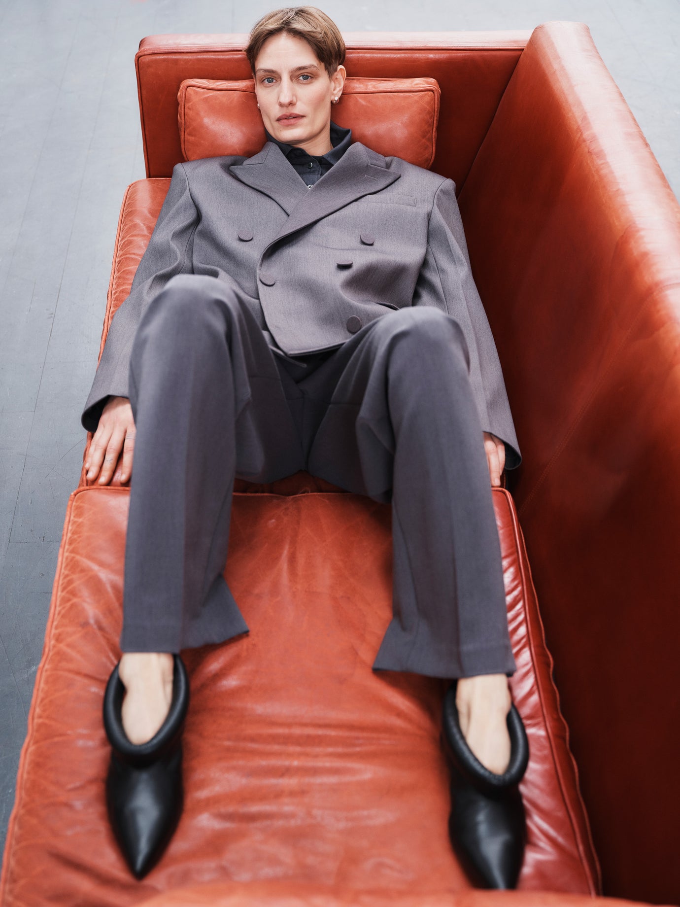 Model Veronika Kunz lying on a sofa wearing The Frankie Shop, photographed by Sarah Blais. 