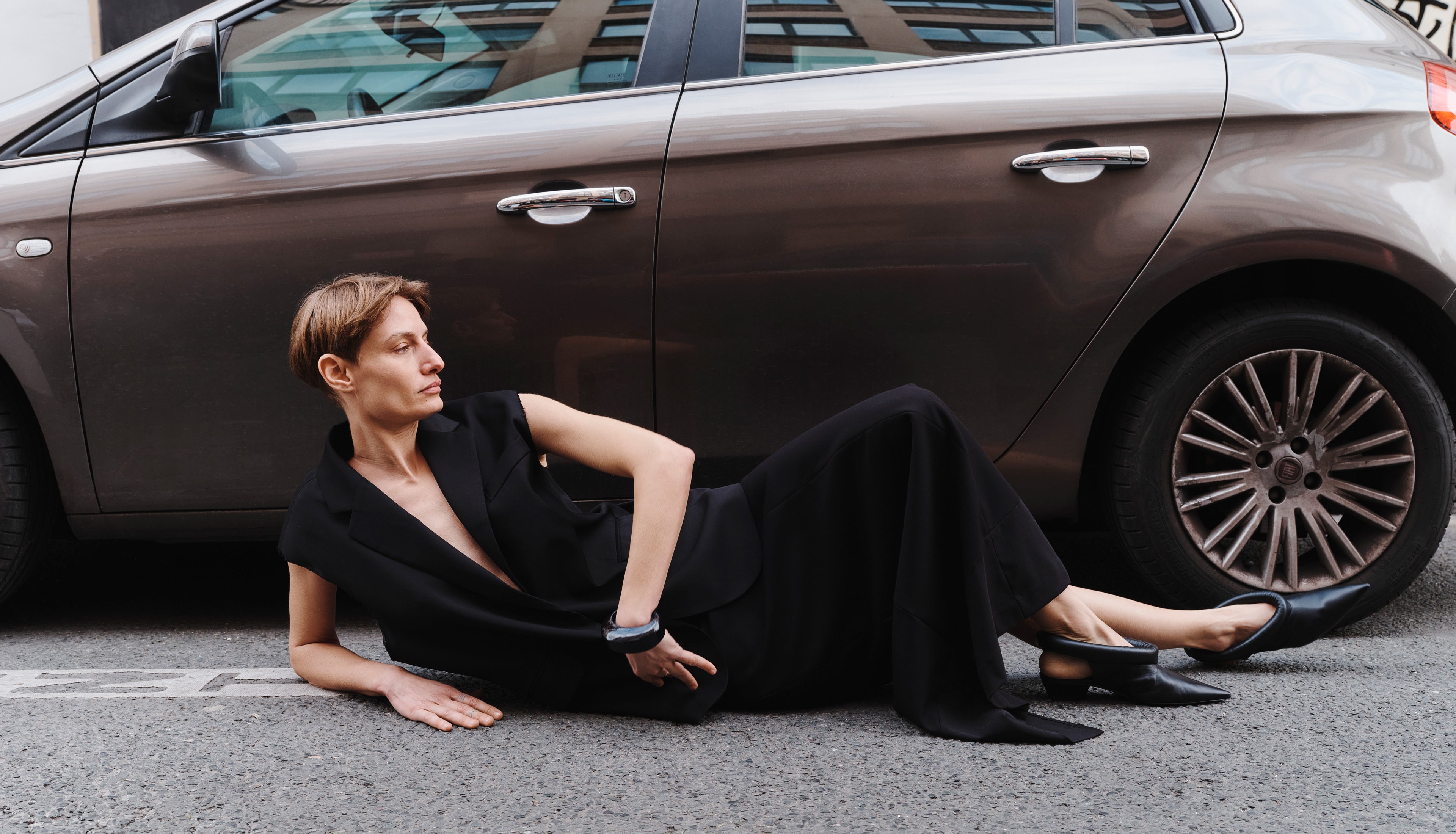 Model Veronika Kunz lying on the ground wearing The Frankie Shop Senol blazer and Demi pencil skirt.